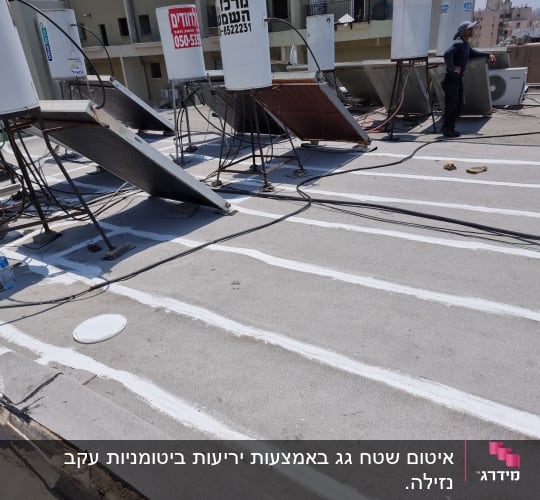 איטום גג עם חומר לבן בין לוחות בטון
